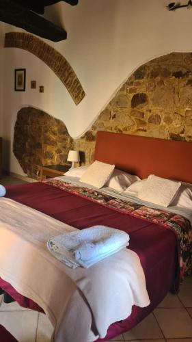 two beds in a room with a stone wall at Casa centro storico borgo medievale in San Mauro Castelverde