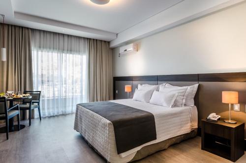 Mira Serra Parque Hotel في باسا كواترو: فندق غرفه بسرير ومكتب وغرفة