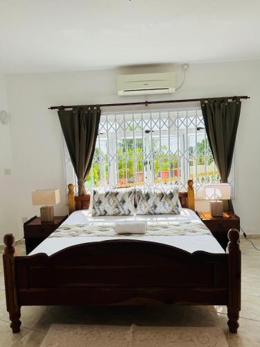 a bedroom with a large bed and a window at D BES Residence Self Catering in Beau Vallon