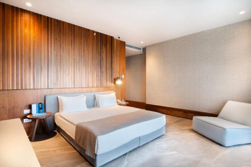 a hotel room with a bed and a chair at Arts Hotel Bodrum Yalikavak in Yalıkavak