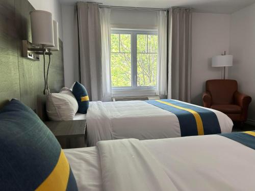 a hotel room with two beds and a window at Hôtel Énergie Shawinigan in Shawinigan