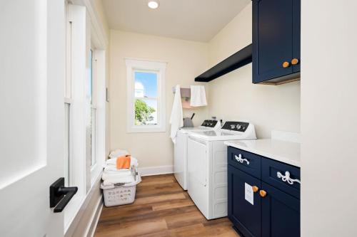 a small kitchen with blue cabinets and a sink at All Sands On Deck in Oak Island
