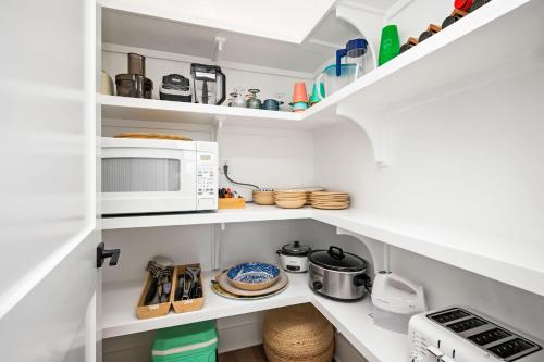 a kitchen with white shelves and a microwave at All Sands On Deck in Oak Island