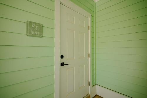 a white door in a house with a sign on it at All Sands On Deck in Oak Island