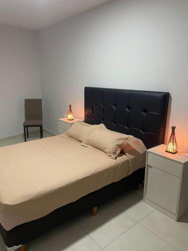 a bedroom with a large bed with two lamps at Encanto floral 2Pax - By Inside in Guaymallen