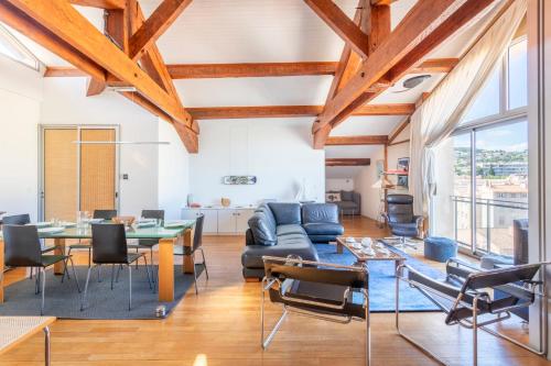 - un salon avec des plafonds en bois, une table et des chaises dans l'établissement La Panoramique du Port - Welkeys, à Bandol
