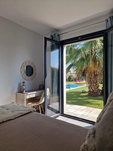 - une chambre avec une porte coulissante en verre menant à une piscine dans l'établissement Villa Saint Laï 4 chambres 8 personnes, à Lorgues
