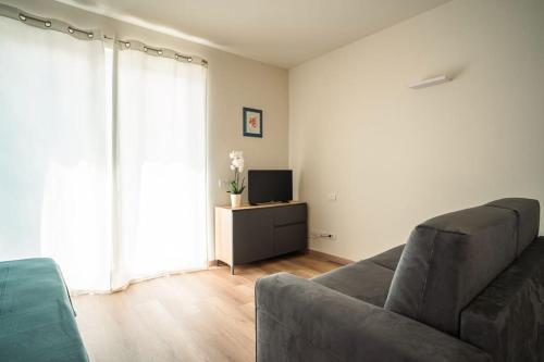 a living room with a couch and a television at Monolocale Moderno Valpolicella Verona - Jala in San Pietro in Cariano