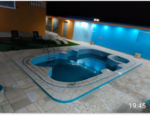 a large swimming pool with a blue pool at Residencial Oliveira in Porto Novo