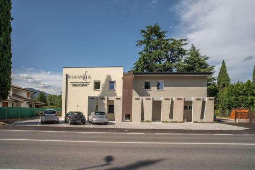a building with two cars parked in a parking lot at Monolocale Moderno Valpolicella Verona - Jala in San Pietro in Cariano