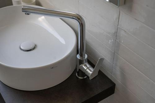 a white sink in a bathroom with a silver faucet at Monolocale Moderno Valpolicella Verona - Jala in San Pietro in Cariano