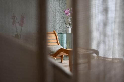 a chair and a glass table with flowers in a room at Monolocale Moderno Valpolicella Verona - Jala in San Pietro in Cariano