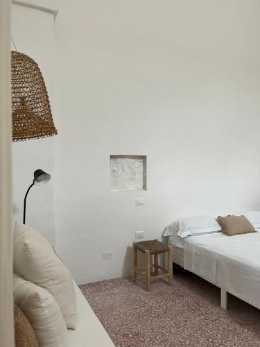a white room with two beds and a table at L’Edicola Votiva in Casarano