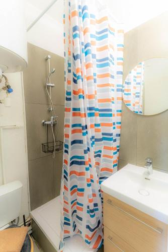 une salle de bain avec un rideau de douche et un lavabo dans l'établissement Sanary Bandol plein SUD, à Sanary-sur-Mer