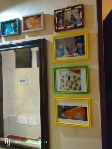a group of pictures on a wall with a mirror at Tri Re e 'na Regina in Cinisi