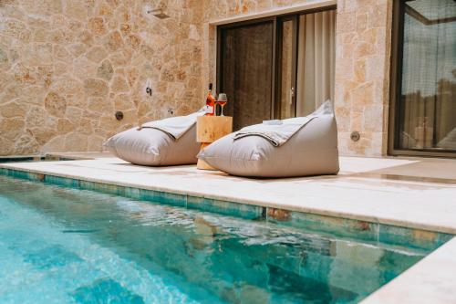 two bean bags sitting next to a swimming pool at Gabbana Beach Villas in Syvota