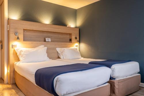 two beds in a hotel room with two at Kyriad Digne-Les-Bains in Digne-les-Bains