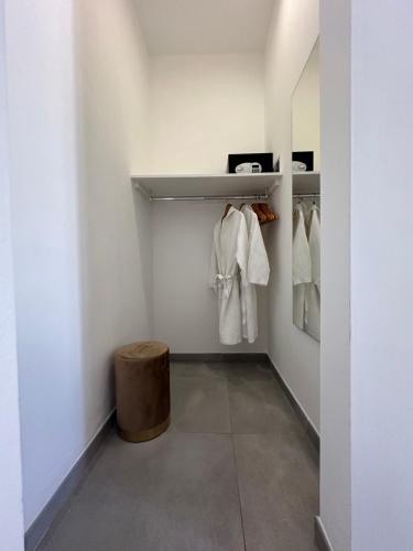 Petra Maris B&B في بيسكيتشي: خزانة ملابس بها مناشف بيضاء ومقعد