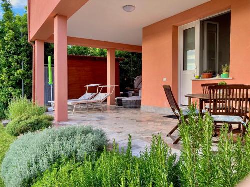 a patio with chairs and a table on a house at La casa nel verde con piscina in Polverara