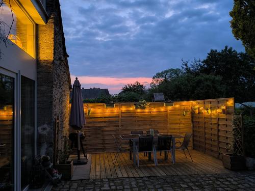 a patio with a table and a fence with lights at Lî Gurni in Houffalize