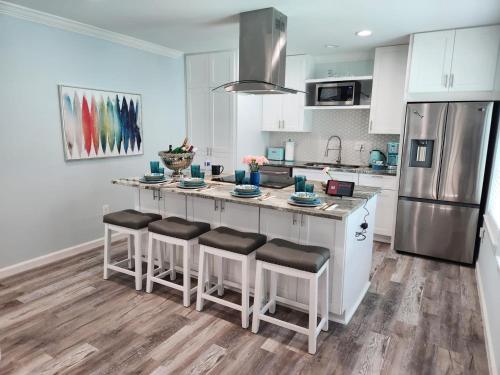 a kitchen with a large island with bar stools at Island Dreams Oasis Galveston Retreat in Galveston