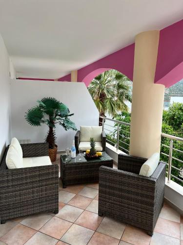 a balcony with wicker chairs and a table and palm trees at Bella Vista in Balíon