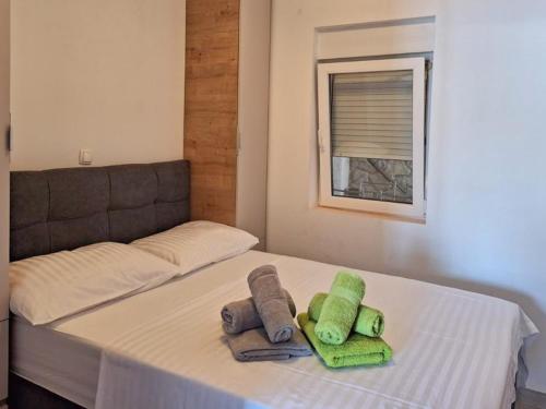 a bed with two towels on it with a window at Apartments Vale in Blace