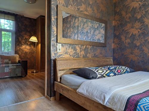 a bedroom with a bed with a picture on the wall at Champêtre Park View Apartments in Rīga