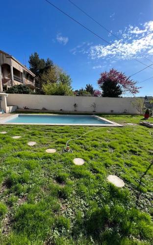 - une piscine dans une cour avec de l'herbe verte dans l'établissement Maisonnette avec jardin piscine non accessible, à Marseille