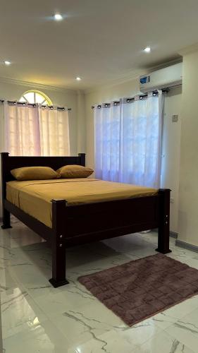 a bedroom with a large bed with blue curtains at Luxurious 2 Bedroom Apartment- Georgetown in Georgetown