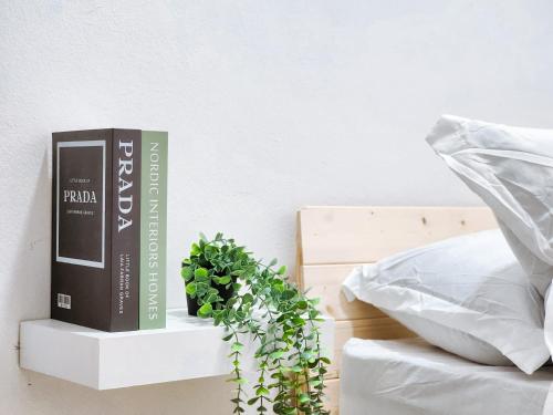 a book and a plant on a nightstand next to a bed at Ar-Rayyan 2 Homestay Kota Bharu in Kota Bharu