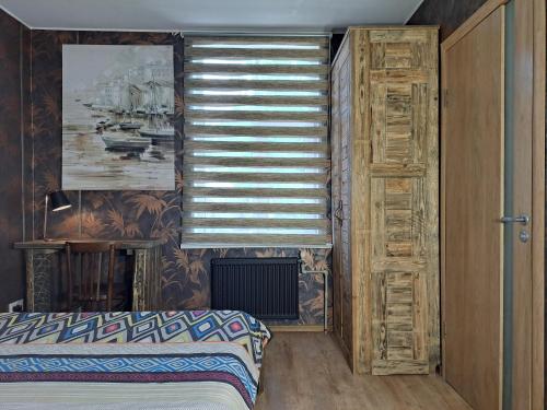 a bedroom with a bed and a window with blinds at Champêtre Park View Apartments in Rīga
