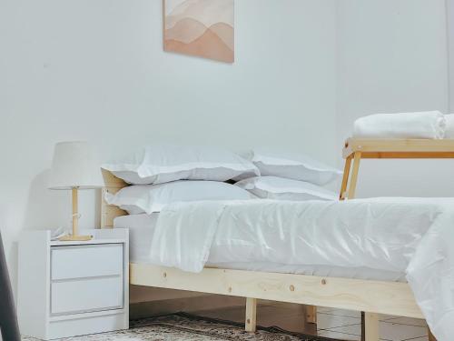 a bedroom with a bed with white sheets and pillows at Ar-Rayyan 2 Homestay Kota Bharu in Kota Bharu