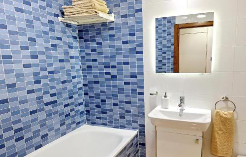 een blauw betegelde badkamer met een wastafel en een toilet bij Apartment with large roof solarium in Orihuela-Costa