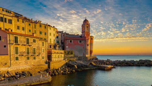 a group of buildings next to the water with a clock tower at Relax a pochi passi dal Mare in Arcola