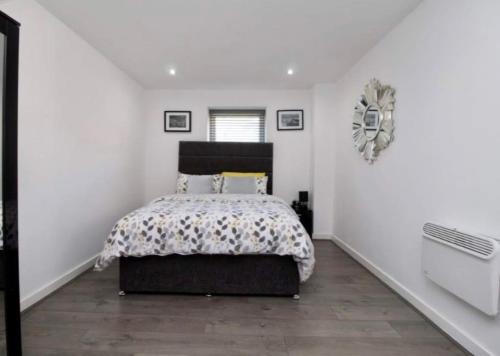 sypialnia z łóżkiem i białą ścianą w obiekcie Campbell Square Apartment 3 w Liverpoolu