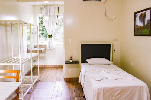 ベチンにあるHotel Primavera Betimのベッドルーム1室(ベッド1台、テーブル、窓付)