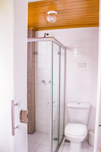 a bathroom with a toilet and a glass shower at Hotel Primavera Betim in Betim
