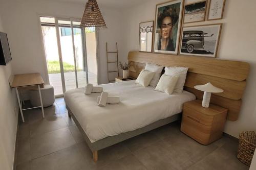 une chambre avec un grand lit blanc avec une grande fenêtre dans l'établissement 300 M de la plage, piscine Clim, wifi, à Grimaud