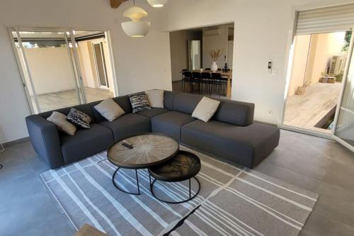 un salon avec un canapé bleu et une table dans l'établissement 300 M de la plage, piscine Clim, wifi, à Grimaud