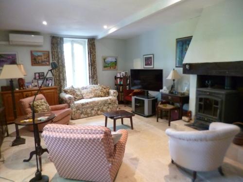 un salon rempli de meubles et d'une cheminée dans l'établissement The Cottage, à Loubès-Bernac