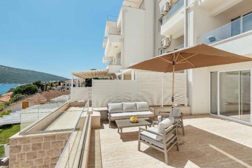 a patio with two chairs and an umbrella at Bella Vista Luxure Apartments in Baošići