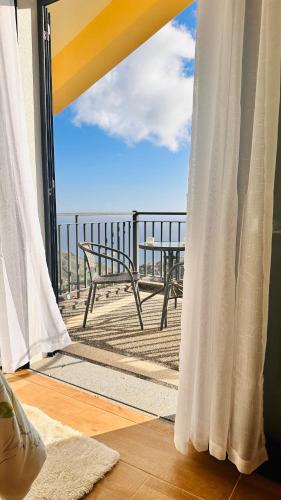 a balcony with a bench and a view of the ocean at BoaVista- 2 bed house -COSY PANORAMIC -SEA - MOUNTAIN VIEW in Campanário