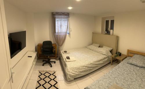 1 dormitorio con 1 cama, 1 silla y TV en Jolie appartement Nice proche mer et aéroport Une chambre plus salon avec cuisine, en Niza