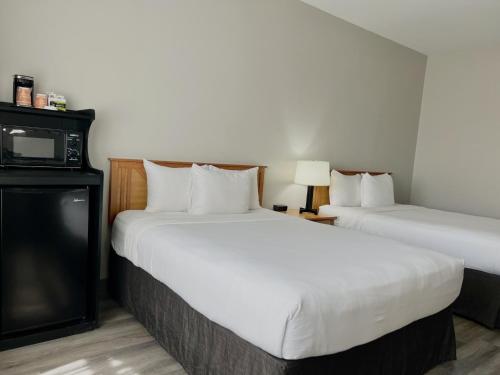 a hotel room with two beds and a tv at Country Inn & Suites by Radisson, Tucson Airport, AZ in Tucson