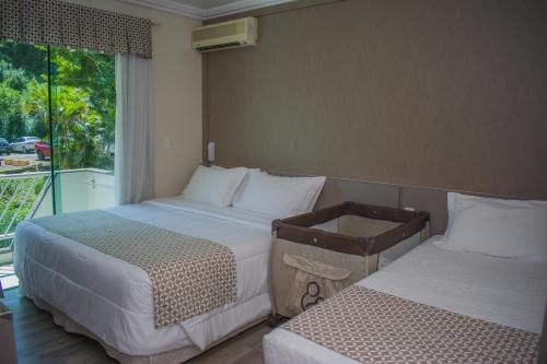 a hotel room with two beds and a window at Itá Thermas Resort e Spa in Itá