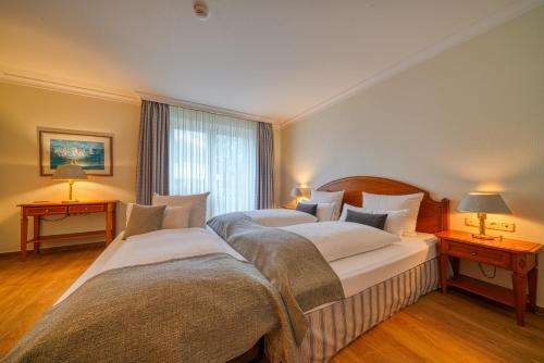 two beds in a hotel room with two lamps at Parkhotel Am Glienberg by NP in Zinnowitz