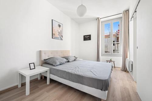 une chambre blanche avec un lit et une table dans l'établissement Appartement F3, 2 chambres, 80m2, à Nice
