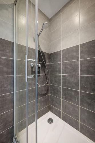 une douche avec une porte vitrée dans une salle de bain dans l'établissement Appartement F3, 2 chambres, 80m2, à Nice
