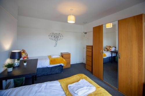 una camera con 2 letti, una scrivania e uno specchio di Granby Grove Townhouse - Sleeps 8- 4 Bedrooms a Southampton